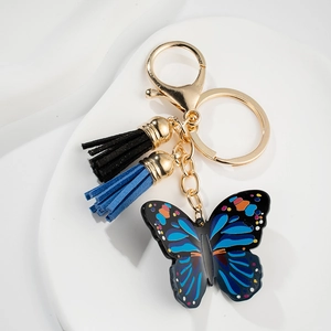 Blue butterfly keychain with golden metal clasp and bicolor tassel on white base