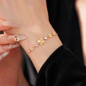 Macro detail of gold plated flower bracelet with opal and zircon on model wrist
