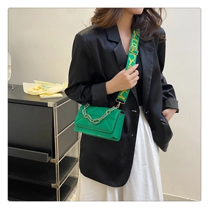 Green quilted flap crossbody bag with wide logo strap and resin chain detail