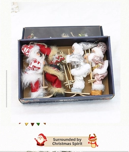 Close-up of four plush Santa skiing doll ornaments with snow poles in a blue gift box