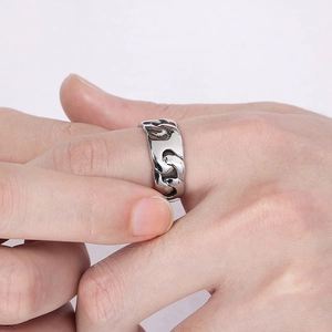 Close-up of a silver-tone Cuban link ring on a finger with a high-polished mirror finish