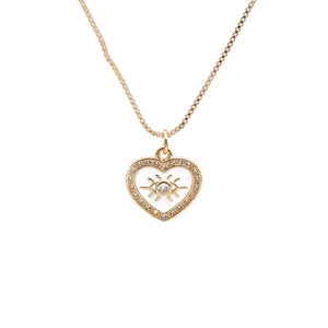 Detail of gold heart pendant with white enamel inlay and evil eye crystal center