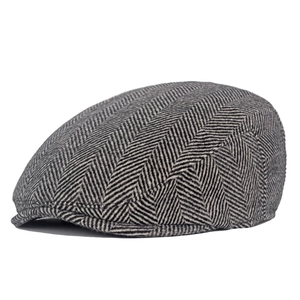 Detailed side view showing classic black and white herringbone tweed pattern on newsboy cap