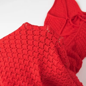 Gros plan sur la maille crochet rouge et le détail du laçage au dos d'une robe