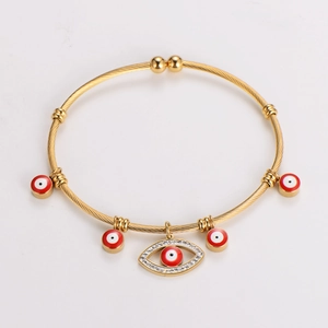 Detail of 18K gold stainless steel twisted bangle with red enamel evil eye charms