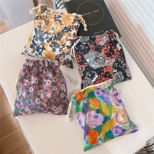 Detail of four floral cotton drawstring pouches with vintage art prints and cord closures