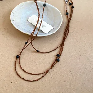 Retro amber acrylic beaded necklace with black heart accents in a layered stackable design