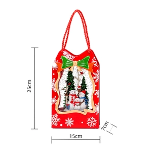 Detail of red Christmas gift bag music box with snowman landscape and green bow decor