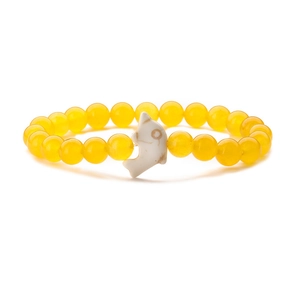Detail of yellow stone bead bracelet featuring a white dolphin charm and elastic band