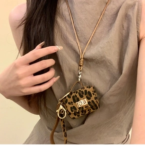 Detail of leopard print mini pouch necklace with gold twist lock and woven strap