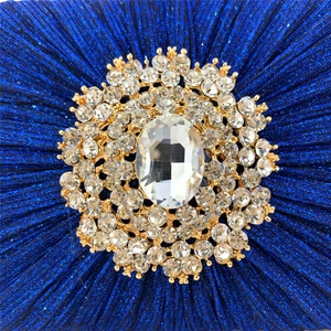 Detail of navy blue pleated evening bag with sparkling crystal and rhinestone buckle