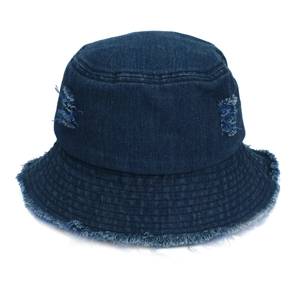 Detail of distressed dark blue denim bucket hat with frayed edges and ripped texture
