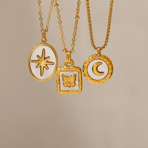 Dettaglio di collane placcate oro 18K con ciondoli a farfalla luna e stella in madreperla