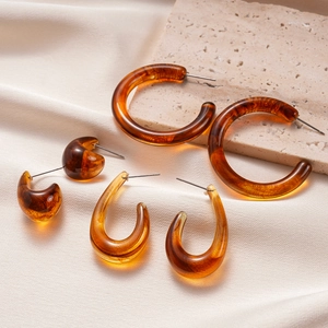 Elegant set of three amber resin earrings in round, teardrop, and C-shapes on stone base