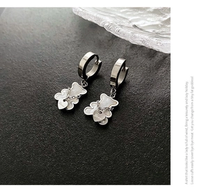 Macro view of silver bear earrings with mother of pearl inlay and love heart charms