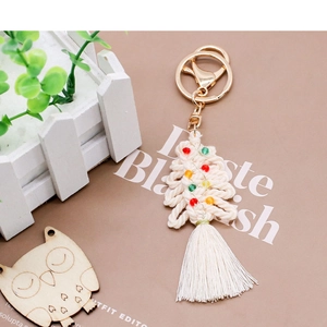 Detail of macrame Christmas tree keychain with colorful beads and white cotton tassels