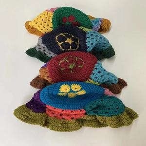 Detailed view of colorful handmade crochet bucket hats with vibrant floral petal patterns