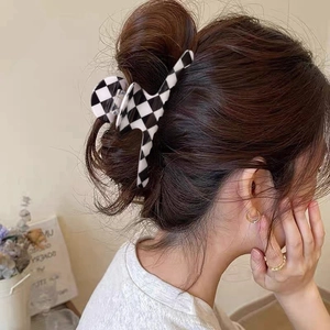Classic black and white checkered acetate hair claw clip worn in a daily updo hairstyle