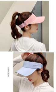 Detail view of pink and blue sun visors with wide brims and adjustable elastic straps