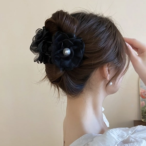 Pince à cheveux fleur en soie noire élégante avec perle blanche sur coiffure femme