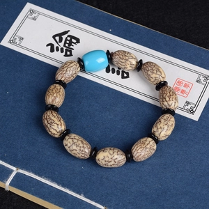 Bodhi-Samen-Armband mit blauer Perle auf traditionellem Buchhintergrund