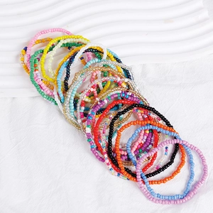 Detailed view of bohemian colorful seed beads stacked bracelets in vibrant rainbow mix