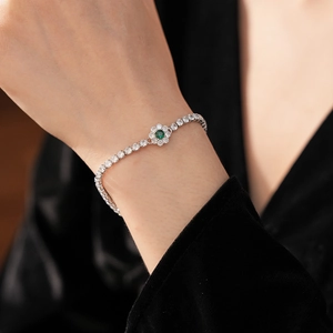 Detailed view of silver flower bracelet with sparkling green and white zircon stones