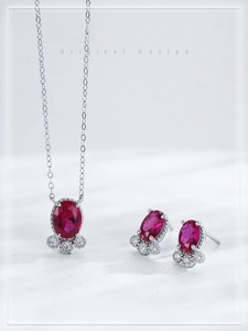 Close-up of S925 silver necklace and earrings set with red oval ruby stones and zircons