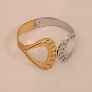 Detail of two-tone hollow geometric stainless steel bracelet with cutout teardrop patterns