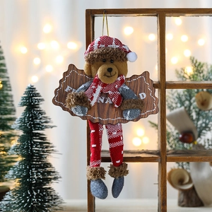 Plush Christmas bear ornament with a wooden sign on a festive tree background