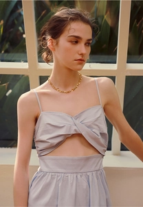 Close-up of golden irregular sequin heart pendant necklace on an elegant woman