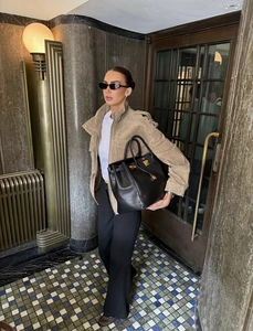 Chic light brown suede jacket styled with wide-leg trousers and a black leather tote bag