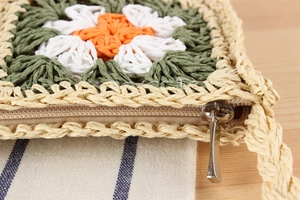 Détail du sac crocheté à la main avec motif de marguerite orange et fermeture éclair