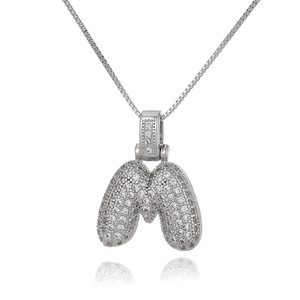Close-up of silver letter M pendant with micro-pave zircons on a box chain necklace