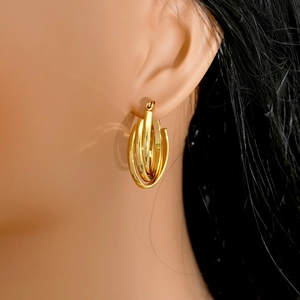 Polished 18k gold triple layered U-shaped stainless steel earrings on female model