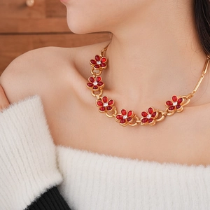 Macro shot of 7 red glass flower necklaces with rhinestones on a golden metal chain