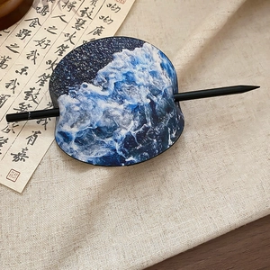 Detail der Haarnadel mit Wellenmuster auf Leinenstoff mit traditioneller Kalligrafie