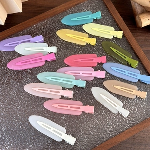 Dettaglio di fermagli per capelli opachi in colori pastello su un vassoio di vetro