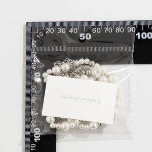 Detail view of pearl and silver bead necklace with ruler for size measurement