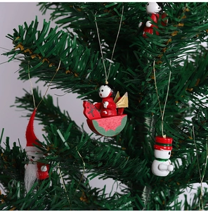 Close-up of wooden Santa, snowman and angel ornaments hanging on a Christmas tree