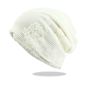 Detail of white hollow lace knit beanie with floral patterns and breathable texture