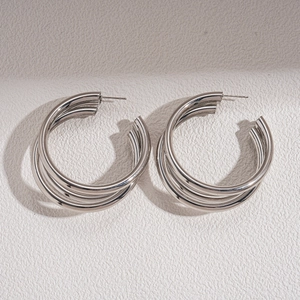 Macro shot of silver multi-layer C-shape hoop earrings with smooth metallic finish