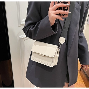 Detail of cream crossbody bag with wide canvas strap and premium lychee grain texture