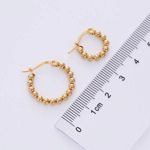 Detailed view of 2cm twisted gold bead hoop earrings with a size reference ruler