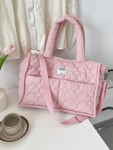 Pink quilted cloud pattern tote bag with double handles and adjustable strap on desk
