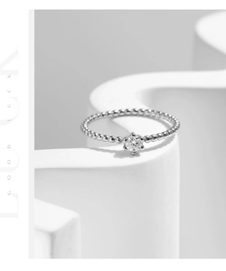 Détail d'une bague perlée en argent S925 avec une pierre centrale ronde en moissanite