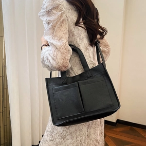 Side view of a minimalist black large-capacity tote bag worn by a model for daily commute