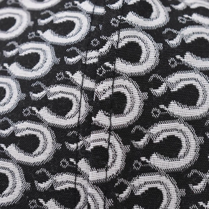 Macro shot of black baseball cap fabric with silver jacquard interlocking ring pattern