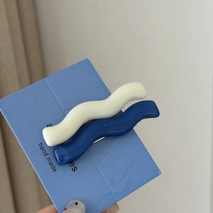 Set of two vintage wavy hair clips in white and navy blue on a display card