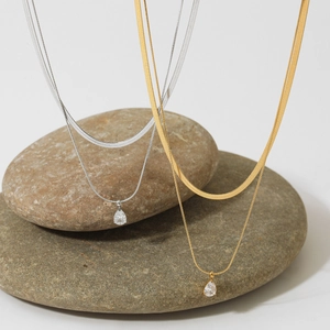 Double-layered snake chain necklace with pear-shaped zircon pendant in gold and silver finish